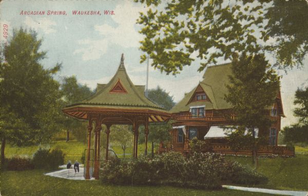 Text on front reads: "Arcadian Spring, Waukesha, Wis." Two people are seated at a "healing mineral spring" with a pavilion and springhouse. The Arcadian Mineral Spring Company was incorporated in 1885 and had a bottling house 300 feet from the spring. Between 1868 and 1918, 60 mineral springs were located here. People would travel here to "enjoy the waters."
