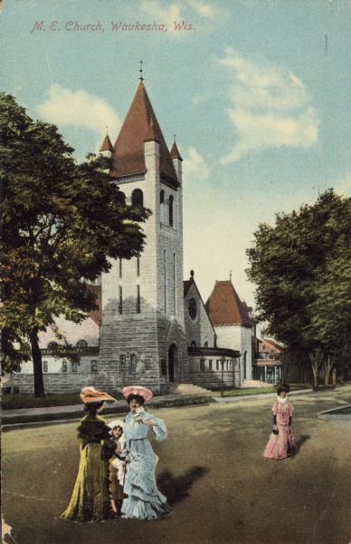 Text on the front reads: "M.E. Church, Waukesha, Wis." Three women and a child stand in the street in front of a limestone church built in 1895 in the Richardson Romanesque style. There are trees on both sides and the women are fashionably dressed.