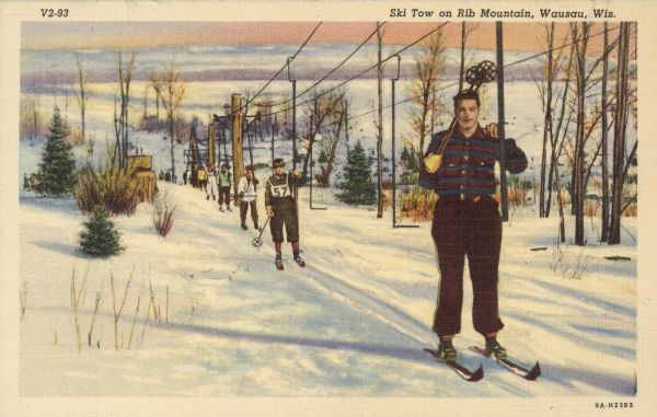 Text on front reads: "Ski Tow on Rib Mountain, Wausau, Wis." On reverse: "Rib Mountain, just outside of Wausau, is a Winter Paradise boasting, among other unrivalled [sic] attractions, an open slope over 400 feet wide and 2,500 feet long. The overhead cable ski tow is 3,150 feet in length and is believed to be the longest of its type in the United States. It services both the open slope as well as the six fine trails, and seventy-five persons can ride it at one time, getting on or off at any point." Skiers on a "surface lift" type ski lift. Snow and trees are visible throughout.