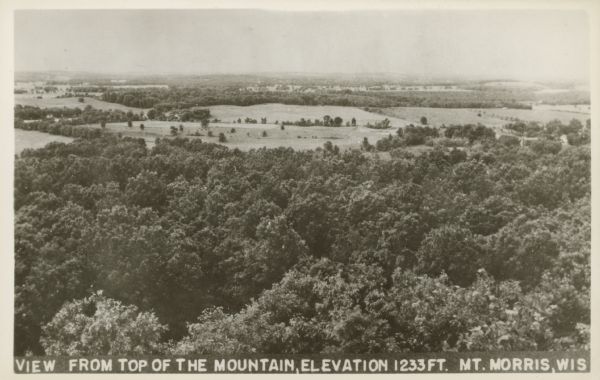Text on the front: "View from the Top of the Mountain, Elevation 1233 ft. Mt. Morris, Wis." View of trees and fields from the highest point in Waushara County.