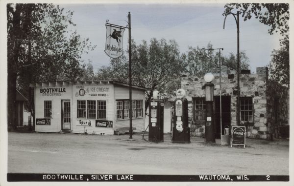 Mobil gas station constructed of split stone. Next door, offering ice cream, soda pop, and groceries to motorists near Silver Lake, was the Boothville grocery. It is possible that Boothville is the name of the store, not the name of the locality.