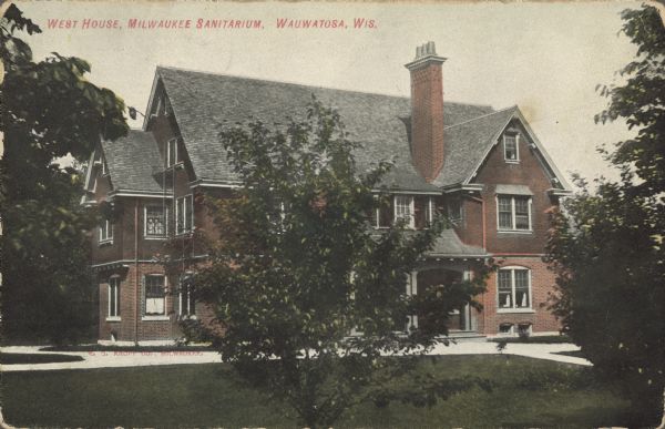 Text on front reads: "West House, Milwaukee Sanitarium, Wauwatosa, Wis. A three-story brick building at the Milwaukee Sanitarium, a privately held institution for the treatment of nervous disorders. It is surrounded by sidewalks, trees and a lawn.