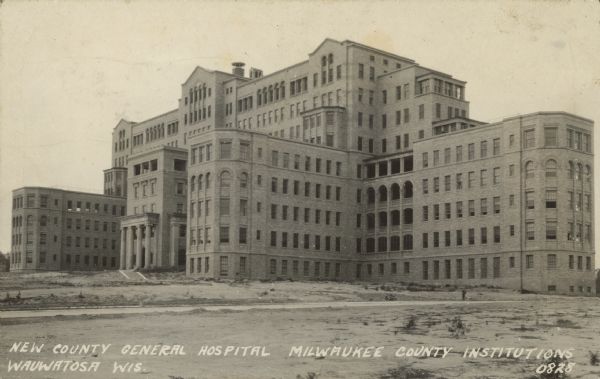 Text on front reads: "New County General Hospital. Milwaukee County Institutions. Wauwatosa, Wis." A multistory, Neoclassical, cream brick hospital built in 1927. Additions were added in 1957.