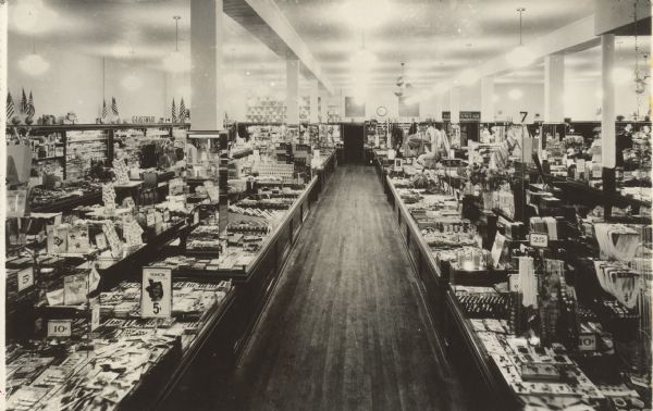 Text on reverse reads: "July 1941. This is an interior view of the new store at West Allis, Wis. The photograph was taken from the front looking towards the rear of the store. W.L. Nolan." An interior view of a traditional "Five and Dime" variety store with merchandise displayed on counters and shelves. The store was opened in the 1920s as McLellan's, renamed McCrory's in 1963, Rentmeester's M.C. Variety in 1996 and finally closed at 1:00 pm on June 21st, 2005.