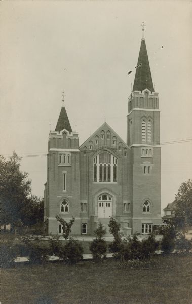 Handwritten on reverse: "Westby Church." A brick church built in the Gothic style with two towers.