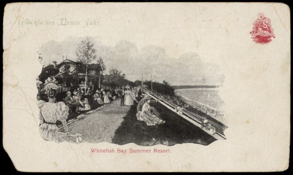 Text on front reads: "Glückliches Neues Jahr [Happy New Year]. Whitefish Bay Summer Resort." A crowd of people are enjoying the grounds and view at a resort on Lake Michigan. They are seated on the lawn, strolling on the sidewalks or on the beach. A building is on the left, with trees throughout.