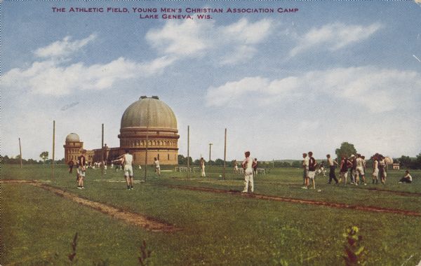 Text on front reads: "The Athletic Field, Young Men's Christian Association Camp. Lake Geneva, Wis." A group of young men exercise on on a large athletic field. The Yerkes Observatory can be seen in the background. In 1886, three men conceived the idea of a YMCA training school, the land was purchased and the training camp established. In 1890, it was moved to Chicago, but the Lake Geneva Campus remained as a "college camp" used for retreats.