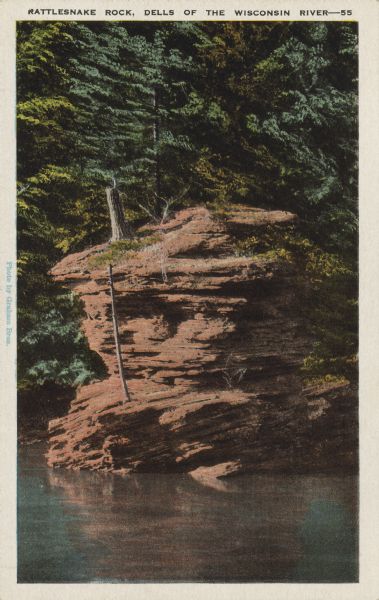 Text on front reads: "Rattlesnake Rock, Dells of the Wisconsin River." On reverse: "Up stream from the Narrows, on the left bank, is Rattlesnake Rock. Looking back, after passing the rock, a snake's head can be seen on top, pointing upstream." A rock formation on the Wisconsin River.