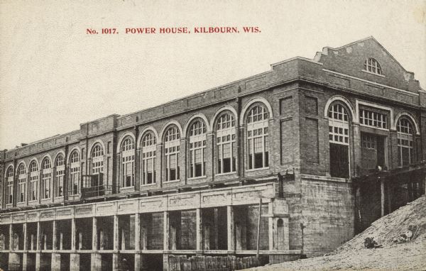 Text on front reads: "Power House, Kilbourn, Wis." A brick building with arched windows. Completed in 1909, the power plant is still in use today.<p>Kilbourn City was founded in 1857 by Byron Kilbourn, the name was changed in 1931 to Wisconsin Dells.</p>