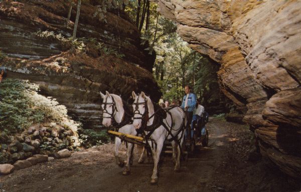 Text on reverse reads: "Lost Canyon, Wisconsin Dells, Wisconsin." Tourists ride in a modern day horse-drawn buggy through Lost Canyon. Rock formations tower overhead.