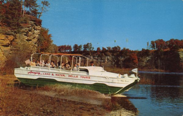Text on reverse reads: "The Original Dells Duck Tour. After descending the rock walled, fern covered trails, your Duck enters the beautiful Lower Dells of the Wisconsin River." Text on the "Duck" reads: "Amazing Land & Water Dells Tours." Ducks are amphibious vehicles used during World WII for the transportation of goods and troops over land and water. The first Original Dells Duck Tour took place in 1946.