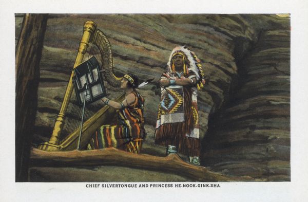 Text reads: "Chief Silvertongue and Princess He-Nook-Gink-Sha." One of 16 postcard images inside of a souvenir view folder. A Native American woman is playing the harp and a Native American man is standing next to her. They are wearing indigenous dress and standing on the ledge of a rock formation. A tree trunk and branch are visible on the foot and left.