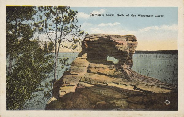 Text on front reads: "Demon's Anvil, Dells of the Wisconsin River." A rock formation and trees above the Wisconsin River, with the opposite shoreline in the background. Demon's Anvil is also known as Devil's Anvil.
