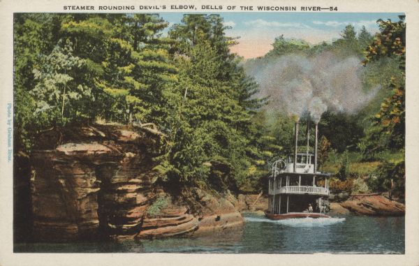 Text on front reads: "Steamer Rounding Devil's Elbow, Dells of the Wisconsin River." On reverse: "This right angle bend in the river is known as the Devil's Elbow. This was named by the raftsmen, because of the great danger in rounding the bend while rafting their logs down the river." A steamer takes passengers on a tour of the Wisconsin River. Rock formations and trees line the shore.