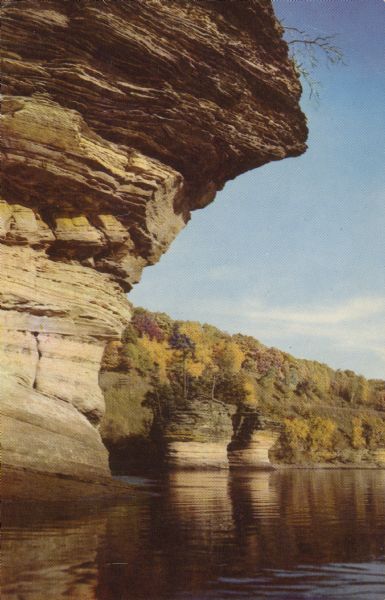 Text on reverse reads: "Inkstand. Dells of the Wisconsin River. Autumn lends its charm to this view of one of the well-known features of the Dells." Tree-topped rock formations are along the shoreline.