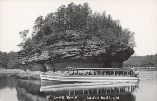 Text on front reads: "Lone Rock. Lower Dells, Wis." The tour boat "Josephine" from the Dells Boat Company glides past an island rock formation. Trees and foliage are growing on the top. The far shoreline is in the distance.