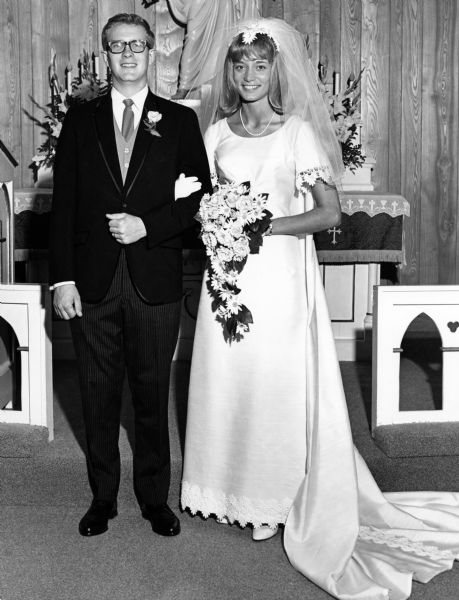 Ed Rath and Lois Beck wedding. The bride and groom are standing in front of the altar. Lois is the daughter of Norm and Marcella Beck.