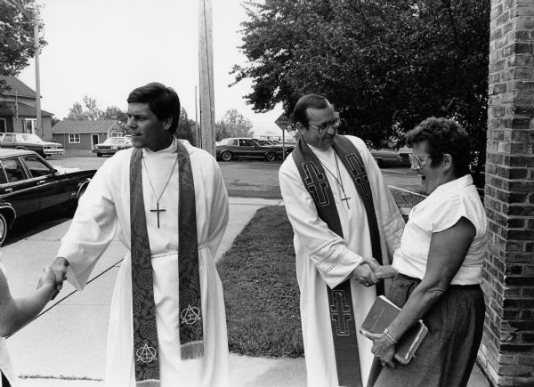 Pastors John Berg and Bob Hoepner greet parishioners outside Saint Peters Lutheran Church.