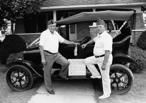 Huber Oechsner and Jim Polster pose with a Beck Motors parade entry.