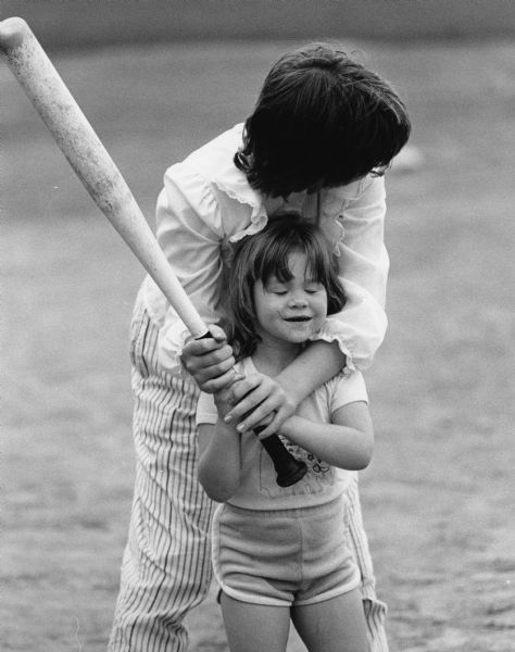 Laura Weymier, with help from her mother Carol, prepares to bat.