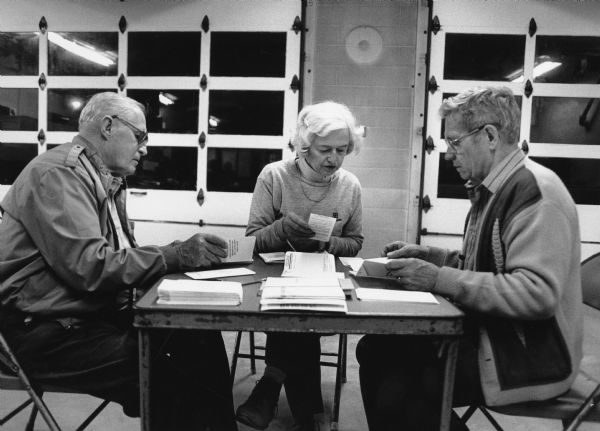 John Bodden, Evageline Koll, and Ralph Ruecker help tally ballots.