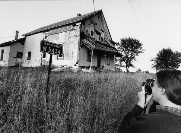 Robert Becker of the <i>Lincoln Star Journal</i> photographs the home in which his father grew up.