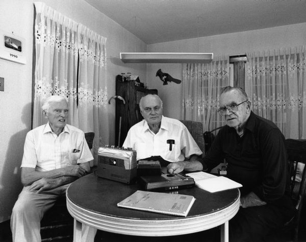 Ralph Widmer, Fred Bandlow, and Les Beck around kitchen table talking over old times.