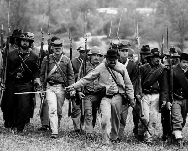 Civil war re-enactors in costume armed with bayonets.