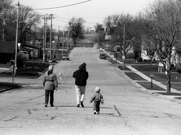 Shirley Widmer with Brenda Wilz and children, Chelsey and Logan, walking down middle of empty street.