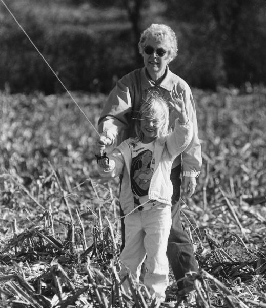 Shirley Widmer flying a kite in a cornfield with her granddaughter, Chelsey.
