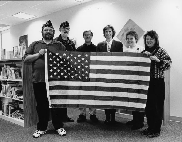 American Legion members Greg Krueger and Al Geiger present a flag to the Theresa Public School. John Streblow, Kathy Sterr, Donna Kanas and Maggie Muehlius represent the school.