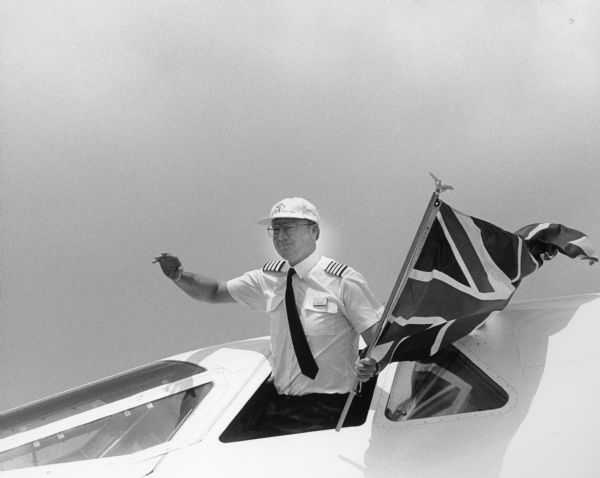 The pilot of the British Concord at the Experimental Aircraft Association's (EAA) Air Show waves to the crowd.