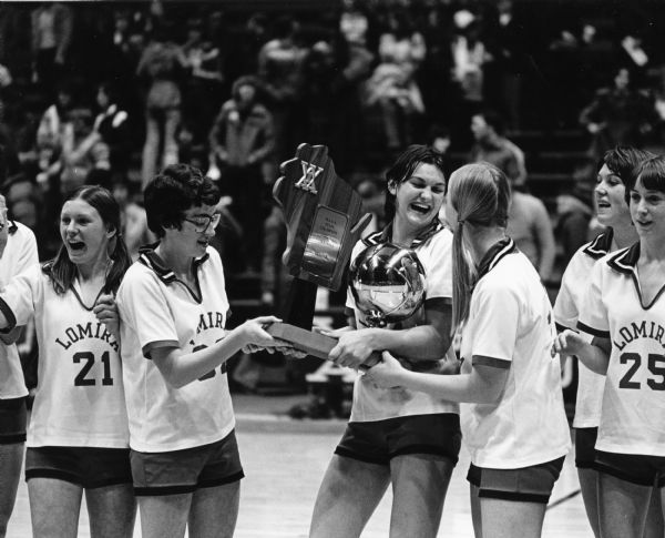 Cheri Sernat, Janice Eimmer, Ann Hall, Mary Beth Wessing, Bev Kuen, and Lisa LaVarda admire the first place trophy for the WIAA Girls Basketball State Championship.