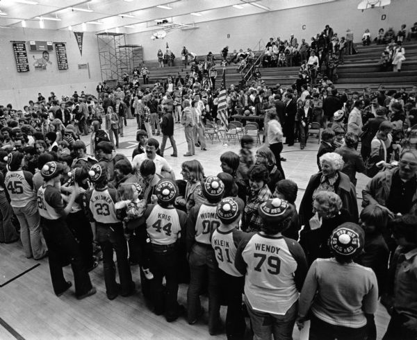 Lomira community members gather in the Lomira gymnasium to greet the team after winning the state basketball tournament.