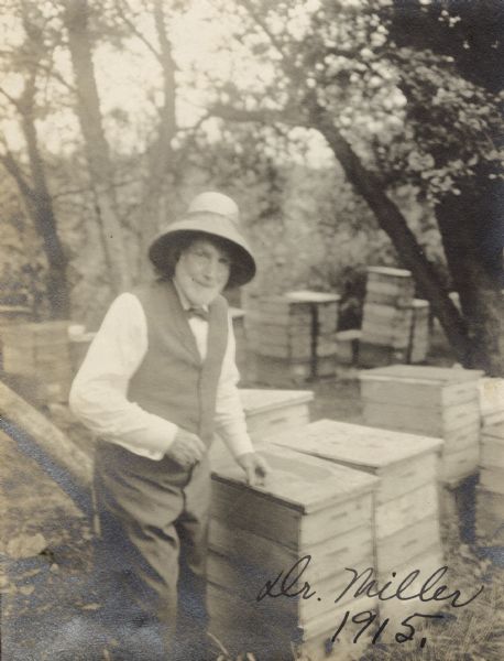 Dr. Charles C. Miller standing among his beehives.
