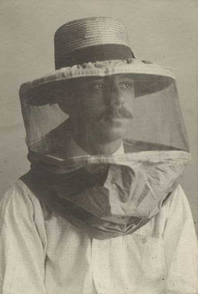 Portrait of an unknown beekeeper, wearing a beekeeping hat and veil.