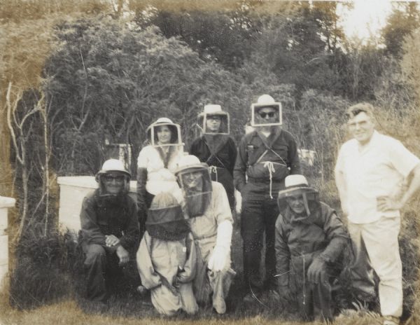 Group portrait of men and women posing outdoors in full beekeeping gear. Part of a class on beekeeping in Wisconsin.