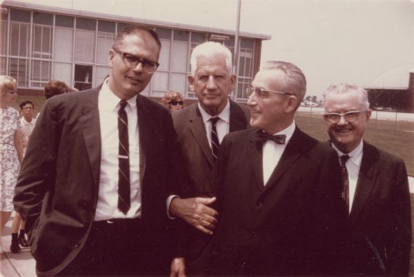 Caption reads: "Arthur Altmeyer poses outdoors with John Engell (last name?), Paul Douglas, and Oscar Ewing at the signing of the Medicare Bill."  Arthur J. Altmeyer (1891–1972) was the United States Commissioner for Social Security from 1946 to 1953, and chairman of the Social Security Board from 1937 to 1946. He was a key figure in the design and implementation of the U.S. Social Security system.