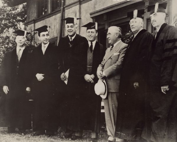 Arthur J. Altmeyer was awarded an honorary LL.D. degree from the University of Wisconsin.<p>Men who received degrees from the University of Wisconsin are, from left to right: Roy Cummings Muir, Vice President of General Electric Co.; Arthur J. Altmeyer, Chairman of the Social Security Board; President Clarence A. Dykstra of the University; Crown Prince Olav; Governor Heil, who did not receive a degree; H.V. Kaltenborn, Radio Commentator; and Mayor Daniel W. Hoan of Milwaukee.
