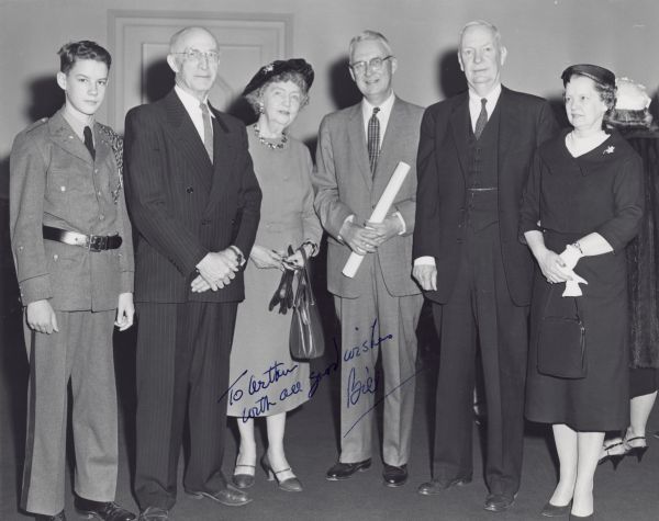 Caption: "William L Mitchell after being sworn in as Commissioner of Social Security. From left to right: his son, George Bigge, Ellen Woodward, Mitchell, Frank Bane, and Mrs. Mitchell." The photograph is inscribed: "To Arthur with all good wishes, Bill."