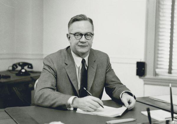 Portrait of Robert M. Ball sitting at his desk, as Deputy Director of the Bureau of Old-Age and Survivors Insurance. In 1962, President Kennedy appointed Ball Commissioner of Social Security, a position he held under three Presidents — retiring in 1973.
