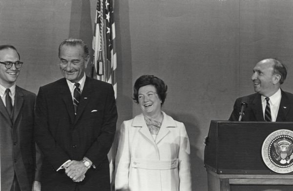 Wilbur J. Cohen, at the podium during his swearing-in as Secretary of Health, Education and Welfare, makes a remark that causes his wife Eloise, President Lyndon B. Johnson and his son Christopher Cohen to laugh. The Social Security office was part of Wilbur Cohen's responsibilities as Secretary of Health, Education and Welfare.