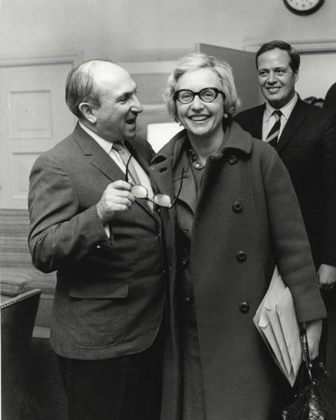 Wilbur J. Cohen with Natalie Davis Spingarn, a speech writer and special assistant to Cohen in the Department of Health, Education and Welfare. There is an unidentified man in the background.