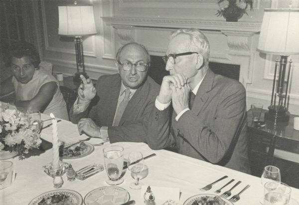 Wilbur Cohen, center, and Arthur Altmeyer right, at a table during the celebration of the 35th anniversary of Social Security enactment. On the left is an unidentified woman.