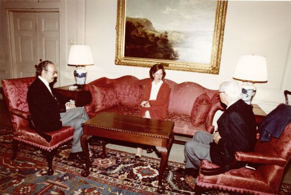 Nelson Cruikshank, Rosalynn Carter and an unidentified man are meeting in a room with red furniture.<p>Nelson Cruikshank worked for the Carter Administration from 1977 through 1980, when he left to head education and research with Wilbur Cohen's Save Our Security organization. As chairman of the Federal Council on Aging, he led efforts to secure and expand social security benefits for the elderly and for people with disabilities.