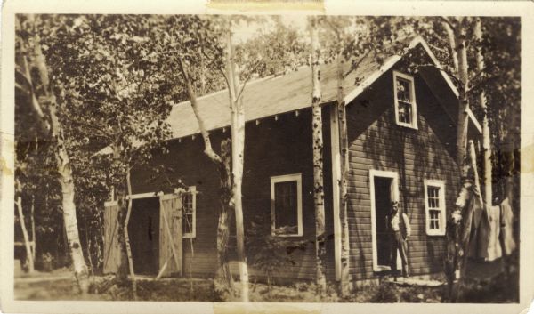 The annotation on the photograph says: "Another picture of the shack - blankets hanging out. Indian Al."<p>Another version of this photograph is annotated: "This is the shack. The door part is where we live and the back is a combination garage and tool shop."