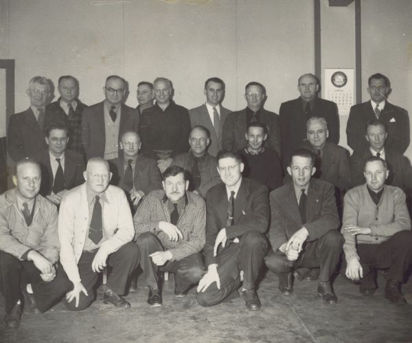In this large indoor group portrait, C.L. (Neal) Harrington is in the second row, second from the right. The men are attending an operational meeting for the Wisconsin Rapids Nursery.