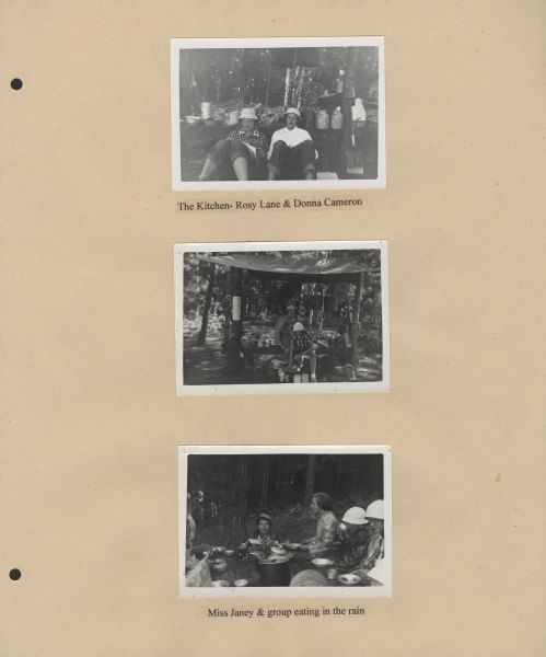 Page from Sue Ann Hackett Blue Album displaying three photographs from the Lake Katherine trip. Includes photographs of campers in the makeshift kitchen with utensils and campers eating with utensils in the rain; some of the campers are wearing hats and clear plastic rain coats.