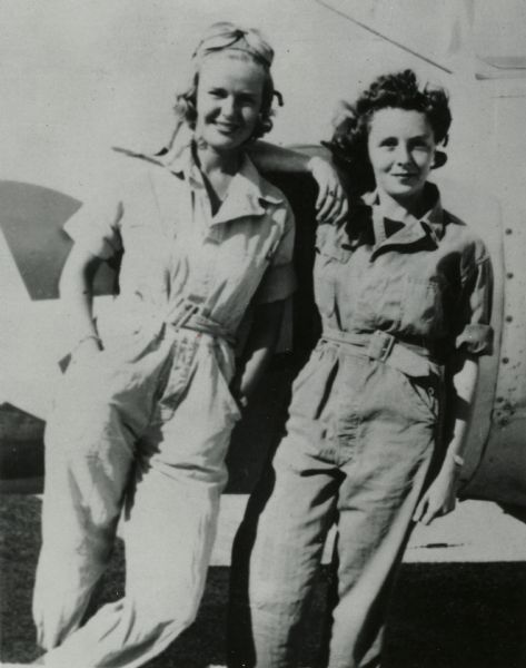 Dorothy Mosher and Pat Hoskins leaning against an airplane.