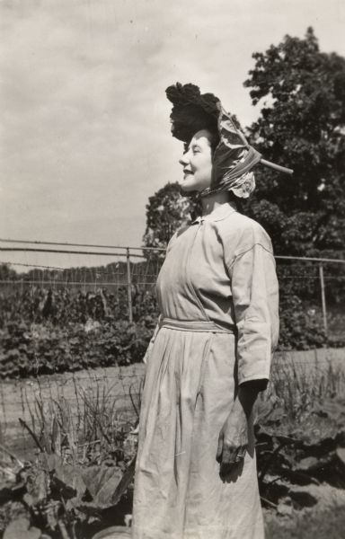 Lynn Fontanne in work clothes and wearing a rhubarb leaf as a hat.